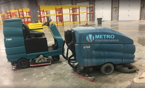 Industrial floor scrubber machines cleaning warehouse concrete floor